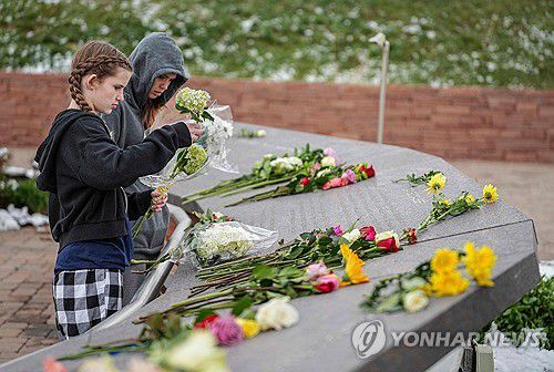 컬럼바인 고등학교 학생들이 지난해 4월 25주기에 희생자 추모비에 꽃을 놓는 모습[AFP 연합뉴스 자료사진. 재판매 및 DB 금지]