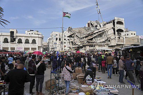 무너진 건물 뒤로하고…무슬림 연휴 앞두고 시장 찾은 가자 주민들(가자시티 AP=연합뉴스) 28일(현지시간) 무슬림 연휴 '이드 알피트르'를 앞두고 팔레스타인 가자지구 가자시티에 들어선 한 시장에서 사람들이 물건을 사고 있다. 2025.03.30