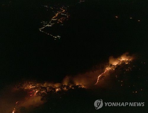 번지는 주왕산 산불(청송=연합뉴스) 김도훈 기자 = 26일 경북 청송 주왕산면 주왕산 능선을 따라 불길이 번지고 있다. 왼쪽 위로는 청송 주왕산면과 청송읍의 불빛이 보이고 있다. 2025.3.26 superdoo82@yna.co.kr