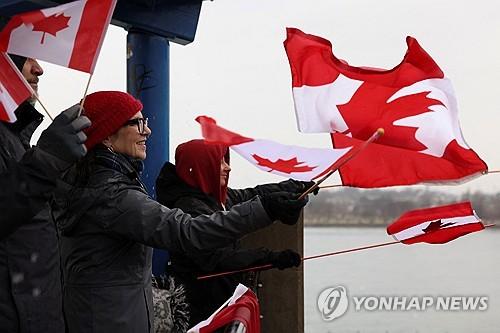 미국 뉴욕주에서 캐나다 국기 흔드는 '캐나다 연대 시위' 주민들[버펄로 로이터=연합뉴스. 재판매 및 DB 금지]
