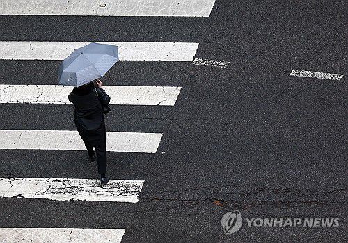 비 내리는 서울(서울=연합뉴스) 이지은 기자 = 비가 내린 27일 서울 종로구 수송동 일대에서 한 시민이 우산을 쓴 채 이동하고 있다. 2025.3.27 jieunlee@yna.co.kr