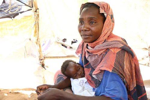 남수단 난민촌서 임시 거주하는 수단 난민(렌크[남수단]=연합뉴스) 성도현 기자 = 수단 난민 수사 아스마일 씨(오른쪽)가 지난달 26일(현지시간) 남수단 국경 지역 난민촌 TC2에서 그의 막내아들(왼쪽)을 안고 지원 내용을 설명하고 있다. 2025.4.11 raphael@yna.co.kr