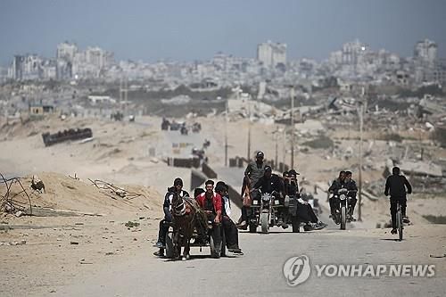 폐허가 된 도시에서 차를 타고 이동중인 가자 주민들 [AFP=연합뉴스 자료사진. 재판매 및 DB금지]
