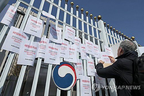 한덕수 해임통지서 붙이는 집회 참가자들(서울=연합뉴스) 류영석 기자 = 15일 정부서울청사 앞에서 열린 한덕수 대통령 권한대행 국무총리의 헌법재판관 후보자 지명 철회 및 사퇴 촉구 긴급서명 전달 기자회견에서 참가자들이 직접 만든 해임통지서를 청사 외벽에 붙이고 있다. 2025.4.15 ondol@yna.co.kr