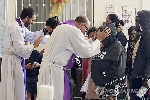 이주민을 축복하고 있는 예수회 신부들 [AP=연합뉴스 자료사진. 재판매 및 DB금지]