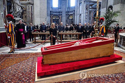 프란치스코 교황의 관이 놓인 받침대(바티칸 EPA=연합뉴스) 23일(현지시간) 조르자 멜로니 이탈리아 총리(가운데)가 바티칸 성 베드로 대성당에 놓인 프란치스코 교황의 관 앞에서 조의를 표하고 있다. 2025.4.23