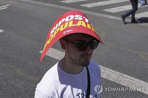 파리 도심 노동절 시위에 참가한 시민이 손팻말로 더위를 피하고 있다. [AP 연합뉴스 자료사진. 재판매 및 DB 금지]