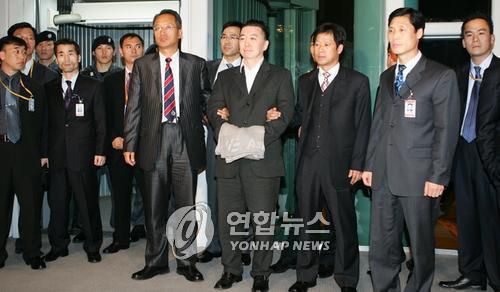 김경준 전 BBK 투자자문 대표 입국(영종도=연합뉴스) 이정훈기자 =  김경준 전 BBK 투자자문 대표가 16일 인천공항을 통해 입국하고 있다. 김경준씨는 입국 게이트에서 취재진에게 30초 가량 사진촬영에만 응하고 계류장으로 빠져 중앙지검으로 떠났다.2007.11.16 uwg806@yna.co.kr