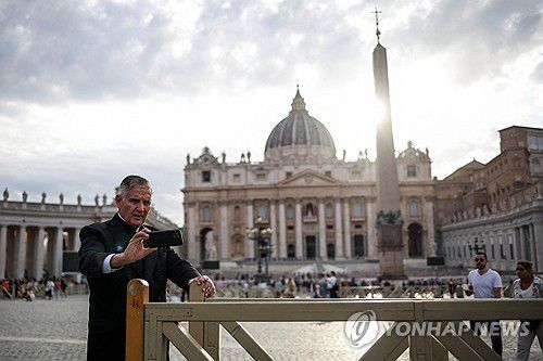 바티칸 성베드로 광장(바티칸 로이터=연합뉴스) 5일(현지시간) 바티칸 성베드로 광장에서 한 신부가 휴대전화를 보고 있다. 2025.05.06