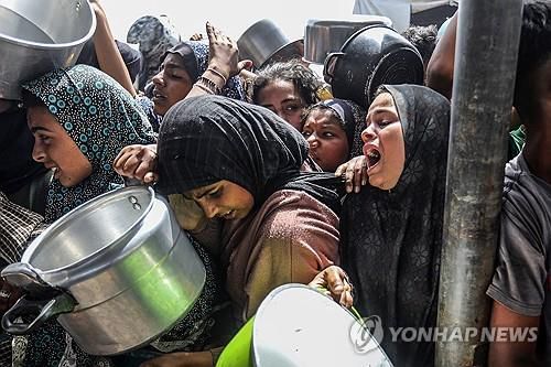 음식 얻으려는 가자지구 주민들(가자지구 칸유니스 UPI=연합뉴스) 2025년 5월 12일 가자지구 칸유니스에서 팔레스타인인 주민들이 구호단체들이 나눠주는 음식을 받으려고 하고 있다. (Photo by Anas Deeb/UPI) 2025.5.14.