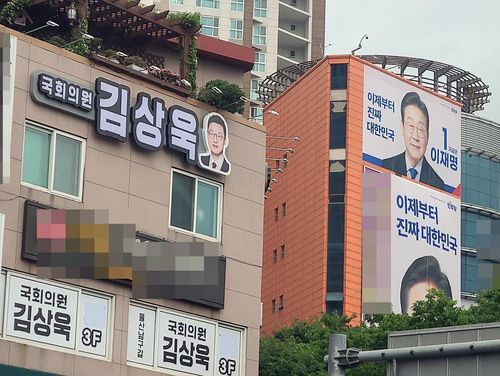 국민의힘을 탈당한 무소속 김상욱 의원의 울산사무실 너머로 이재명 더불어민주당 대선후보의 대형 현수막이 걸려 있다. 김 의원은 15일 이 후보 지지를 공식 선언했다. [촬영 허광무]