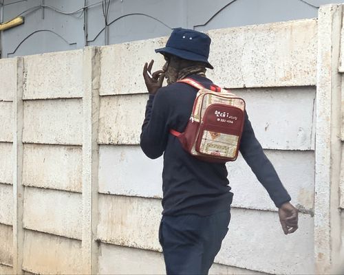 한국어가 적힌 어린이집 가방을 멘 짐바브웨인담배를 든 그는 어디서 이 가방을 구한 것일까? 2024.8.4. 저자 촬영 [이은별 제공. 재판매 및 DB 금지]