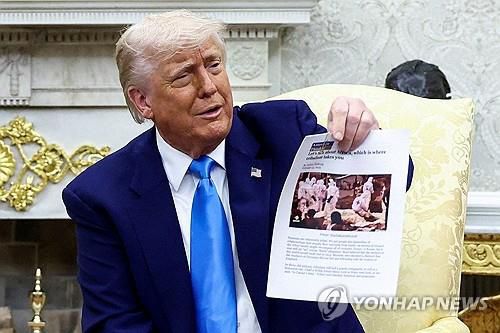 '남아공 백인 학살' 증거라며 기사 인쇄물 들어 보이는 트럼프 대통령[로이터 연합뉴스 자료사진. 재판매 및 DB 금지]