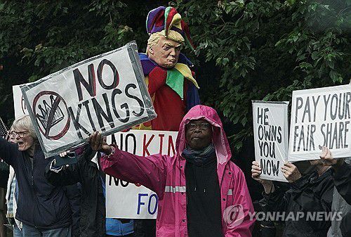 트럼프 밈코인 행사에 항의하는 시위대(미국 버지니아주 스털링 로이터=연합뉴스) 2025년 5월 22일 미국 버지니아주 스털링의 트럼프 내셔널 골프 클럽 입구에서 시위대가 시위를 벌이고 있다. (REUTERS/Ken Cedeno) 2025.5.24.