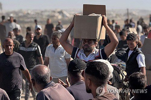 구호품 챙겨 돌아가는 팔레스타인 주민(라파 AFP=연합뉴스) 27일(현지시간) 가자지구 남부 라파의 GHF 배급소에 팔레스타인 주민이 몰렸다. 2025.5.28 photo@yna.co.kr