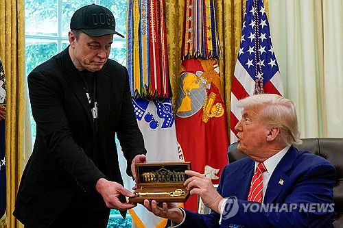 30일 머스크에게 '황금 열쇠' 선물하는 트럼프 대통령[로이터 연합뉴스. 재판매 및 DB 금지]