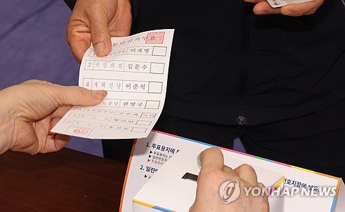 제21대 대선 본투표 시작(제주=연합뉴스) 박지호 기자 = 제21대 대통령선거일인 3일 오전 제주시 연동 제1투표소가 마련된 제주도의회 의원회관에서 한 유권자가 투표용지를 배부받고 있다. 2025.6.3 jihopark@yna.co.kr