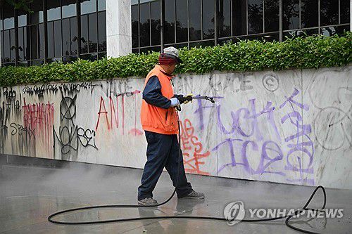 9일 오전 LA 도심에서 시위대가 남긴 낙서를 지우는 청소 노동자[AFP=연합뉴스. 재판매 및 DB 금지]