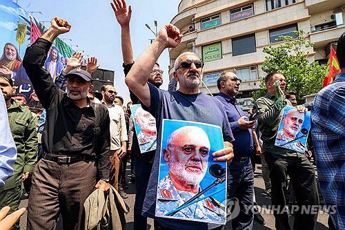사망한 이란혁명수비대 사령관 사진 들고 있는 이란 시위대(테헤란 AFP=연합뉴스) 13일(현지시간) 이란 수도 테헤란에서 시위대가 이스라엘의 공격을 규탄하는 시위를 벌이고 있다. 2025.06.14
