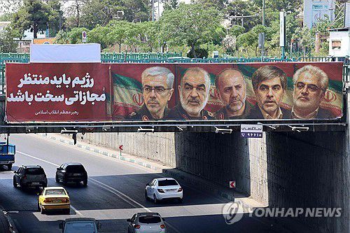 테헤란 다리에 걸린 사망한 이란 군 장성과 핵과학자의 모습[AFP 연합뉴스 자료사진. 재판매 및 DB 금지]