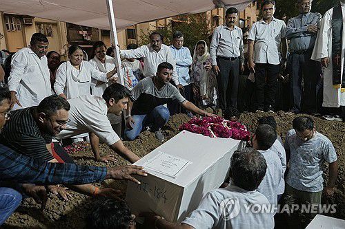 안장되는 인도 여객기 추락사고 희생자들[AP 연합뉴스. 재판매 및 DB 금지]