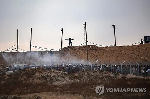식량 배급 받기 위해 몰려든 주민들에게 길 안내하는 GHF 직원[AFP=연합뉴스]