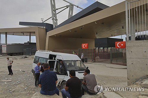 국경 통로 앞에서 기다리는 사람들(귀르블락 AP=연합뉴스) 16일(현지시간) 귀르블락 국경을 넘어 튀르키예에 도착한 사람들이 차량 앞에 앉아서 기다리고 있다. 2025.06.17