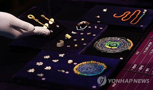 공주 무령왕릉과 왕릉원 조사성과 발표(서울=연합뉴스) 진연수 기자 = 17일 서울 중구 한국의 집에서 열린 공주 무령왕릉과 왕릉원 조사성과 언론공개회에서 출토 유물들이 전시되어 있다.     국가유산청과 국립부여문화유산연구소는 "공주 무령왕릉과 왕릉원을 조사한 결과, 2호 무덤 주인은 백제의 제23대 왕인 삼근왕(재위 477∼479)으로 추정된다"고 밝혔다. 또한 연구소는 2호분에서 화려한 금 귀걸이와 함께 출토한 어금니(2점)의 법의학 분석결과 10대왕이던 심근왕을 추정된다는 결과도 얻었다. 2025.6.17 jin90@yna.co.kr