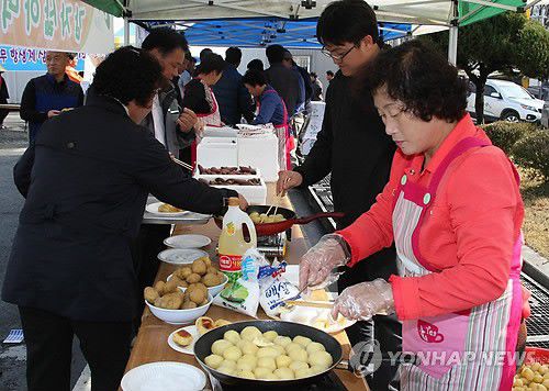 "감자구이 맛있어요"(괴산=연합뉴스) 민웅기 기자 = 충북 괴산군 청안면 농업인단체협의회가 18일 면사무소 광장에서 연 자매결연지와 기업체 직원 초청 행사에 참여한 소비자들이 감자구이를 맛보고 있다. 2011.11.18. wkimin@yna.co.kr (끝)