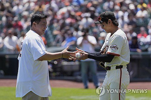 시구한 김태균 해설위원(왼쪽)과 공을 받은 이정후[AP=연합뉴스]
