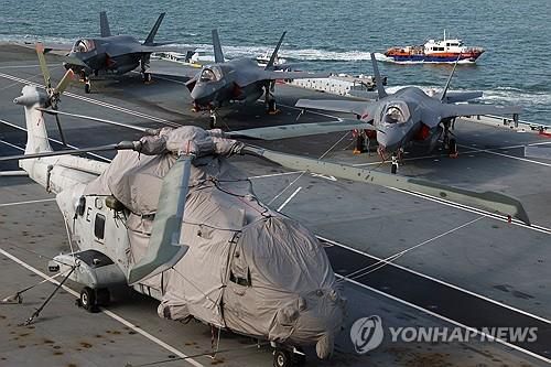 영국 항공모함 함상의 헬리콥터와 전투기(싱가포르 로이터=연합뉴스) 2025년 6월 24일 싱가포르의 마리나베이 크루즈 센터에 입항해 있는 영국 해군 항공모함 '프린스오브웨일스' 함상 비행갑판에 멀린 헬리콥터 한 대와 F-35B 라이트닝 Ⅱ 몇 대가 세워져 있다. (REUTERS/Edgar Su) 2025.6.25.