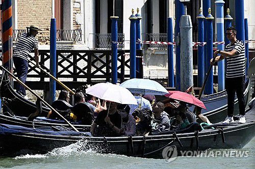 우산으로 더위 막는 베네치아 관광객들[AFP 연합뉴스. 재판매 및 DB 금지]