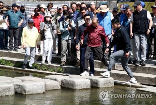 청계천 징검다리 폴짝폴짝 넘는 이명박    (서울=연합뉴스) 이지은 기자 = 이명박 전 대통령이 15일 오전 서울 청계천에서 '청계천을 사랑하는 모임'(청사모) 구성원들과 옛 참모들과 함께 산책하고 있다.  2023.5.15 [공동취재]