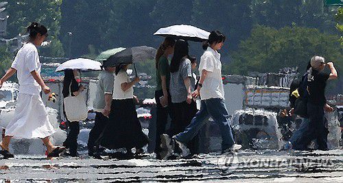 일주일째 폭염, 펄펄 끓는 도심(대구=연합뉴스) 윤관식 기자 = 대구에 일주일째 폭염특보가 발효 중인 3일 대구 달서구 계명대학교 인근 도로에 지열로 인한 아지랑이가 피어오르는 가운데 시민들이 양산을 쓰고 이동하고 있다. 2025.7.3 psik@yna.co.kr