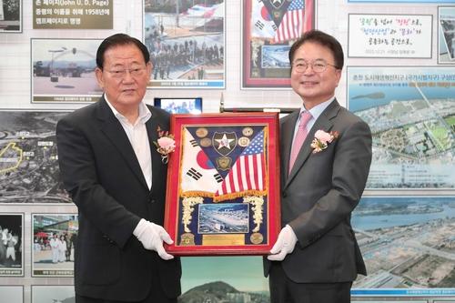 류종수 전 춘천시장(왼쪽)이 육동한 춘천시장에게 반환 당시 기념패 전달[춘천시 제공.재판매 및 DB 금지]