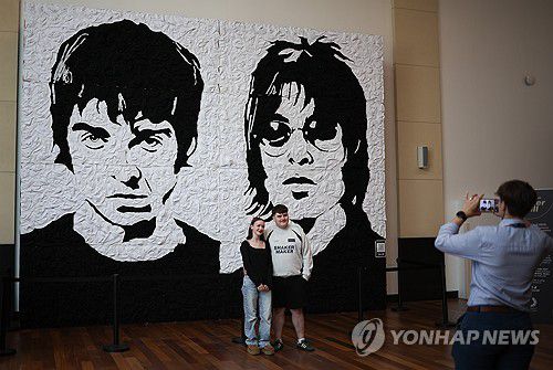갤러거 형제 벽화 앞에서 기념촬영하는 팬들[EPA 연합뉴스 재판매 및 DB 금지]