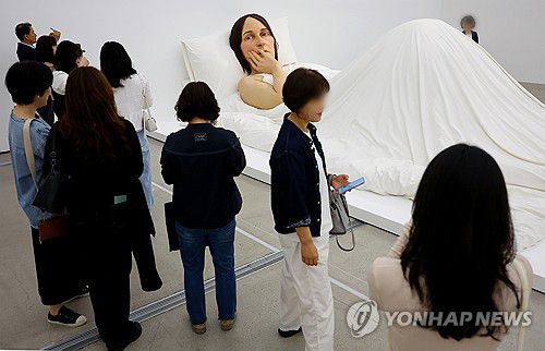 극사실주의 조각가 론뮤 뮤익 개인전, 관람객 21만명 돌파(서울=연합뉴스) 김도훈 기자 = 국립현대미술관 서울관에서 전시 중인 호주 출신 극사실주의 조각가 론 뮤익의 개인전이 관객 수 21만 명을 넘어섰다.      20일 국립현대미술관에 따르면 지난달 11일부터 이달 18일까지 뮤익의 전시회에 일 평균 5천600명(주말 6천777명, 평일 4천611명)이 전시장을 방문해 서울관 개관 이래 단일 전시로는 최다 관람객 기록을 세웠다.      조각 작품 10점과 스튜디오 사진 연작 12점 및 다큐멘터리 필름 두 편 등을 관람할 수 있는 이번 전시는 7월 13일까지 진행된다.      20일 서울 종로구 국립현대미술관을 찾은 관람객이 뮤익의 '침대에서' 작품을 감상하고 있다. 2025.5.20 superdoo82@yna.co.kr