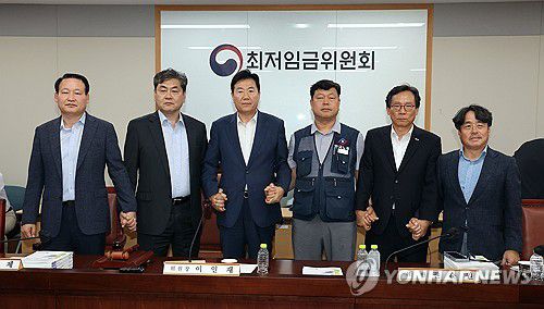 내년 최저임금 시간당 1만320원…17년만에 합의로 결정(세종=연합뉴스) 배재만 기자 = 이인재 최저임금위원장(왼쪽 두 번째)이 10일 정부세종청사에서 열린 제12차 전원회의에서 내년 최저임금을 시간당 1만320원으로 17년만에 합의로 결정한 뒤 공익위원-사용자위원-근로자위원과 손을 잡고 있다. 2025.7.10 scoop@yna.co.kr