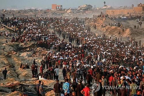 밀가루 구호품을 지고 이동하는 가자 주민들[AFP 연합뉴스 자료사진. 재판매 및 DB 금지]