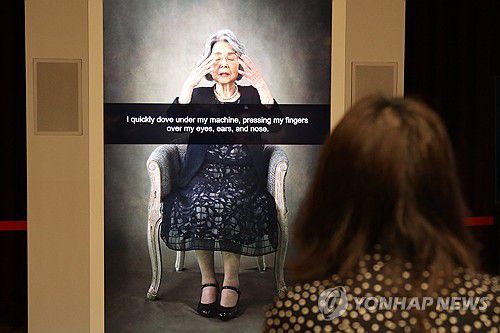히로시마 피폭자의 경험담 증언 영상(히로시마=연합뉴스) 박상현 특파원 = 1945년 일본 히로시마에 원자폭탄이 투하됐을 당시 14세였던 가지모토 요시코 씨가 했던 피폭 경험담을 영상으로 보여주는 '피폭증언 응답장치'. 지난 9일 NHK 히로시마 방송국에서 한 여성이 응답장치에 질문한 뒤 대답을 듣고 있다.
