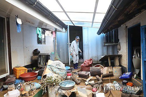 폭우 피해 주택(예산=연합뉴스) 한종구 기자 = 18일 오전 충남 예산군 삽교읍 하포리 폭우 피해 현장에서 주민이 아수라장으로 변한 집안을 바라보며 한숨짓고 있다. 2025.7.18. jkhan@yna.co.kr