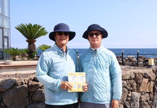 조상백·이윤계씨(제주=연합뉴스) 백나용 기자 = 지난 8일 제주시 용담레포츠공원 주변 해안도로에서 '공항 안전 불법 드론 감시단' 조상백(왼쪽)·이윤계 씨가 인터뷰 후 포즈를 취하고 있다. 2025.7.20 dragon.me@yna.co.kr