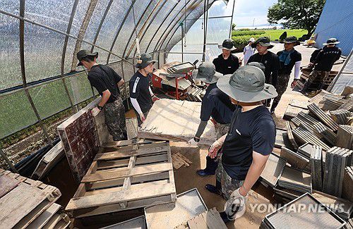 땀 흘리는 육군 장병(예산=연합뉴스) 김준범 기자 = 육군 장병들이 21일 충남 예산군 삽교읍에서 호우로 침수 피해를 본 비닐하우스 농가를 돕고 있다. 2025.7.21 psykims@yna.co.kr