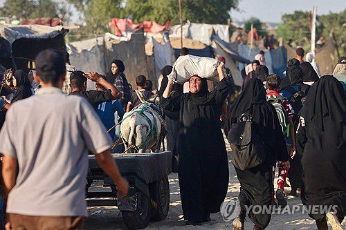 가자지구(라파 AFP=연합뉴스) 24일(현지시간) 가자지구 남부 라파의 마와시 지역에서 한 여성이 구호품을 머리에 이고 있다. 2025.7.24 photo@yna.co.kr