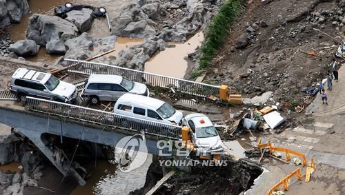 2007년 9월 태풍 나리 당시 붕괴된 제방과 찌그러진 자동차[연합뉴스 자료사진]