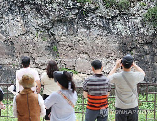 반구대 암각화 보러 온 관람객들(울산=연합뉴스) 김용태 기자 = 13일 울산시 울주군 대곡리 반구대 암각화 전망대에서 시민이 망원경으로 암각화를 관람하고 있다. 지난 12일 '울주 대곡리 반구대 암각화'와 '울주 천전리 명문과 암각화'로 구성된 '반구천의 암각화'가 유네스코 세계유산으로 등재됐다. 2025.7.13 yongtae@yna.co.kr