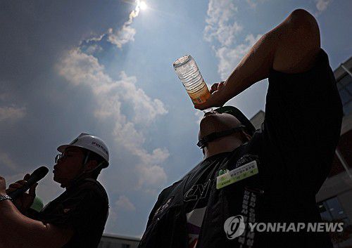 '타는 목마름'(서울=연합뉴스) 김도훈 기자 = 29일 서울 종로구 국정기획위원회 앞에서 열린 민주노총 건설노조 폭염 실태 기자회견에서 참가자가 물을 마시고 있다. 2025.7.29 superdoo82@yna.co.kr