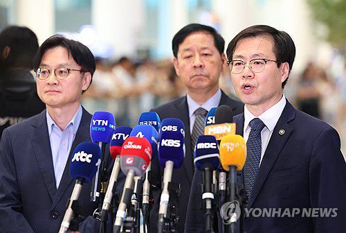 취재진 질문에 답하는 여한구 통상교섭본부장(서울=연합뉴스) 김도훈 기자 = 미국과의 무역협상을 마친 여한구 통상교섭본부장이 1일 인천국제공항 제2여객터미널을 통해 귀국해 취재진 질문에 답하고 있다.      왼쪽부터 김정관 산업통상자원부 장관, 구윤철 경제부총리, 여 본부장. 2025.8.1 superdoo82@yna.co.kr