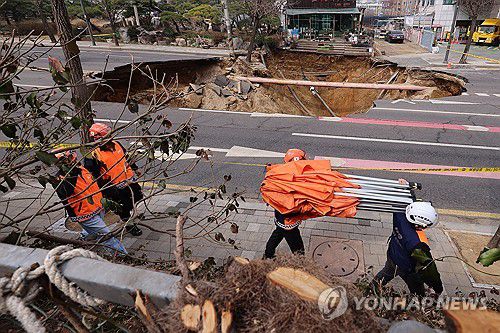 서울 한복판에 발생한 대형 땅꺼짐(서울=연합뉴스) 서대연 기자 = 25일 강동구 대명초등학교 도로에서 전날 발생한 대형 땅꺼짐 현장의 모습.      전날 오후 명일동 대명초등학교 인근 사거리에서 발생한 지름 20ｍ, 깊이 18ｍ가량의 대형 싱크홀(땅꺼짐)에 오토바이 운전자 1명이 빠져 실종됐다. 2025.3.25 dwise@yna.co.kr