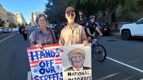 워싱턴치안에 군투입한 트럼프 반대하는 시민 (워싱턴=연합뉴스) 조준형 특파원 = 미국 노동절(9월1일)을 앞둔 주말인 30일(현지시간) 수도 워싱턴 DC에서 반(反)트럼프 시위가 벌어졌다.      이날 수백명의 시위 참가자는 워싱턴 경찰 업무를 연방 정부 통제 하에 두고, 시내 순찰에 군(주방위군)을 투입한 도널드 트럼프 대통령의 최근 결정을 비판하는 구호를 외치며 시 중심가를 행진했다.    행진에 참가한 한 70대 워싱턴 시민 부부가 기자에게 플래카드를 들어 보이고 있다.   2025.8.31 jhcho@yna.co.kr